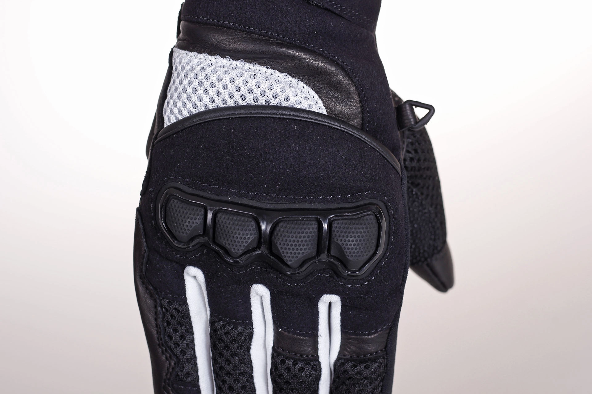 Twardy ochraniacz kostek w czarno-białych rękawicach motocyklowych HUSAR GRIZZLY